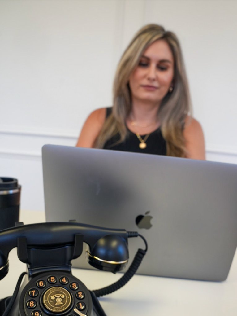 Leader working thoughtfully at desk with vintage phone in foreground